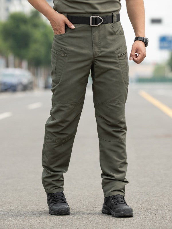 Person wearing olive green tactical pants on a blurred street background