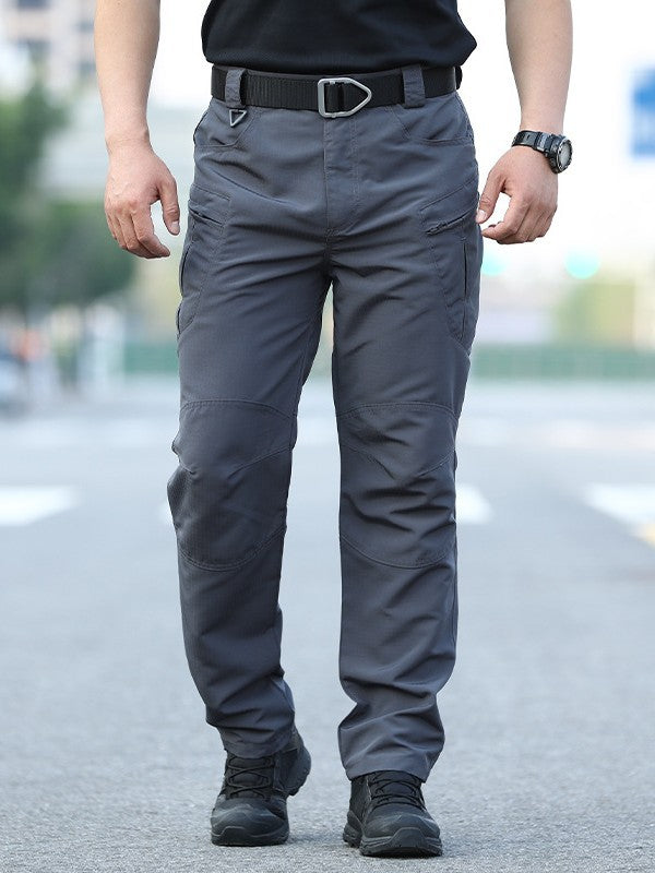 Person wearing gray tactical pants on a blurred street background