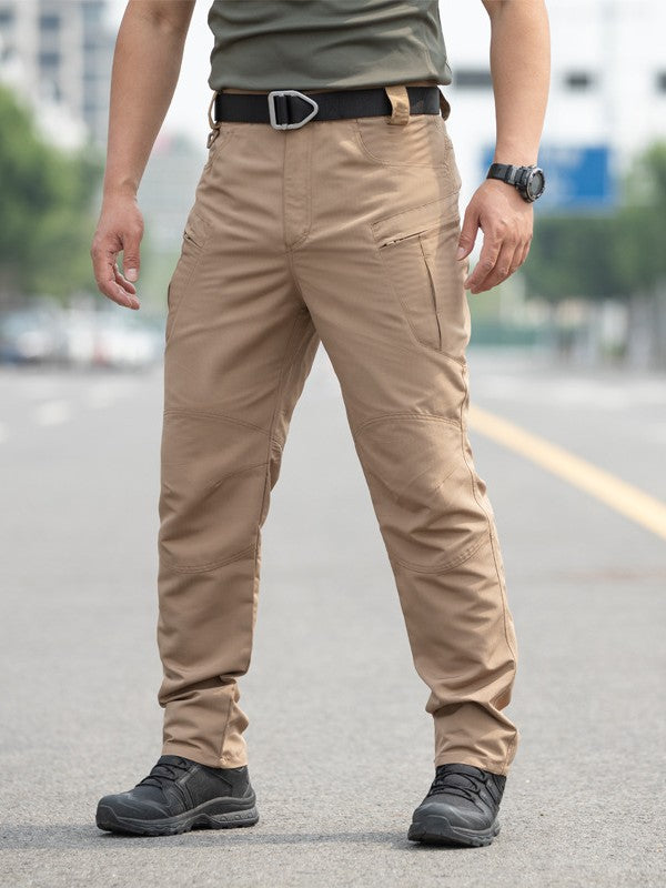 Person wearing beige pants and black shoes on a blurred street background
