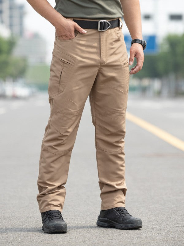 Person wearing beige tactical pants on a blurred street background